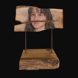 young womans face painted onto a slab of wood
