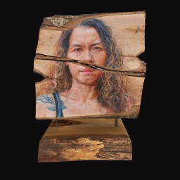 womans face painted onto a slab of wood