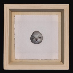 White ceramic cat face mounted in a wooden frame