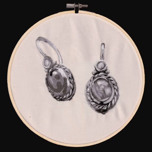 Embroidered pair of earrings on a cream fabric circle