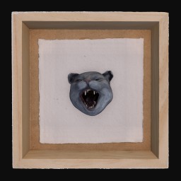 Blue cermaic cat face with open mouth mounted in wooden frame
