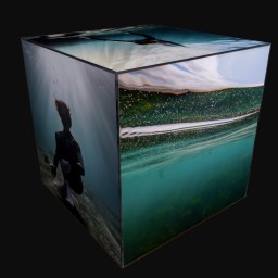 cube sculpture with images of silhouette swimming in ocean underwater and beach landscape