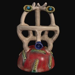 Face-like scultpure with a red base and small blue eyes